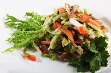 Sebzeli salata ve tabakta biftek.