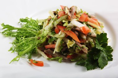 Sebzeli salata ve tabakta biftek.