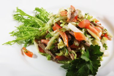 Sebzeli salata ve tabakta biftek.