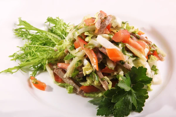 Sebzeli salata ve tabakta biftek.