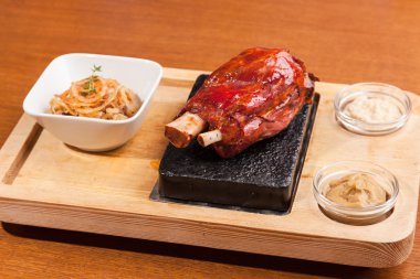 Lahana turşulu domuz budu ve ahşap masada yabanturpu.