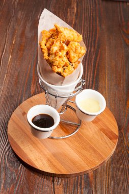 Tahta masadaki kese kağıdında tavuk parçaları.