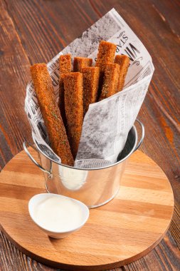 Rye croutons in a paper bag on wooden table
