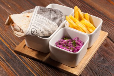 Salatalı shawarma ve tahta masada patates kızartması.