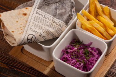 Salatalı shawarma ve tahta masada patates kızartması.