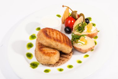 Beyaz tabakta garnitürlü pirzola.