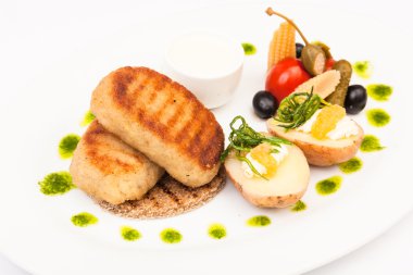 Beyaz tabakta garnitürlü pirzola.