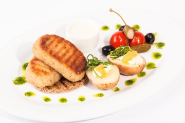 Beyaz tabakta garnitürlü pirzola.