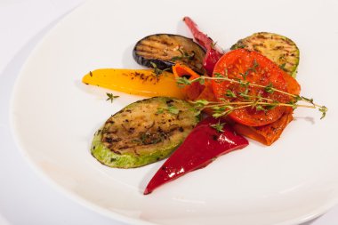 Beyaz tabakta patlıcan ve kabakla ızgara sebze.