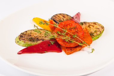 Beyaz tabakta patlıcan ve kabakla ızgara sebze.