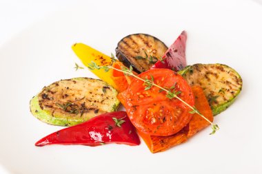 Beyaz tabakta patlıcan ve kabakla ızgara sebze.