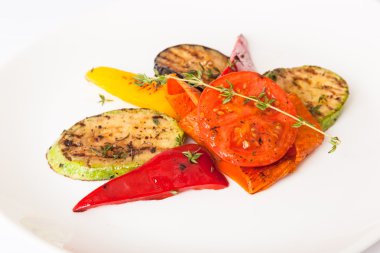 Beyaz tabakta patlıcan ve kabakla ızgara sebze.