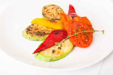 Beyaz tabakta patlıcan ve kabakla ızgara sebze.