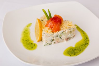 Kırmızı balıklı salata ve beyaz tabakta havyar.