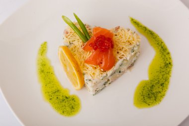 Kırmızı balıklı salata ve beyaz tabakta havyar.