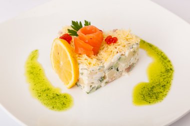 Kırmızı balıklı salata ve beyaz tabakta havyar.