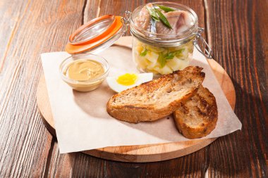 Tuzlu ringa balığı ve ahşap tabakta yumurtalar.