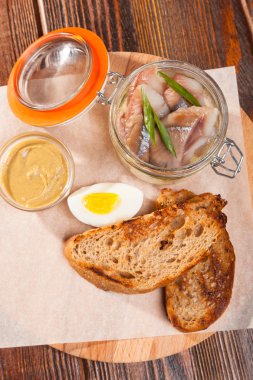 Tuzlu ringa balığı ve ahşap tabakta yumurtalar.