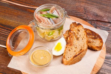 Tuzlu ringa balığı ve ahşap tabakta yumurtalar.