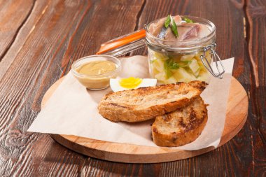 Tuzlu ringa balığı ve ahşap tabakta yumurtalar.