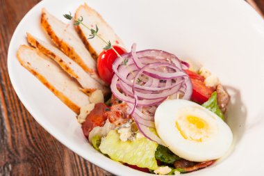 Kiraz domatesli tavuk göğsü salatası ve beyaz tabakta yumurta.