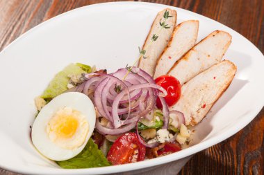 Kiraz domatesli tavuk göğsü salatası ve beyaz tabakta yumurta.