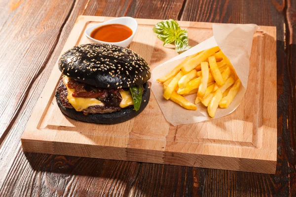 Black Burger Mit Pommes Und Soße Auf Holztisch — Stockfoto