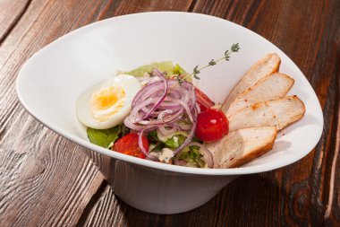 Kiraz domatesli tavuk göğsü salatası ve beyaz tabakta yumurta.