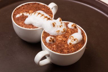 Kedi şeklinde köpüklü kahve ve kahverengi masanın üzerinde fare.