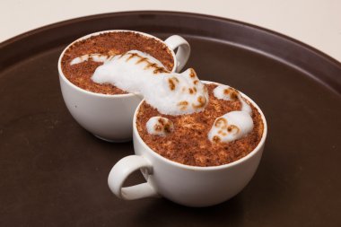 Kedi şeklinde köpüklü kahve ve kahverengi masanın üzerinde fare.