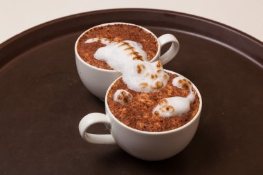 Kedi şeklinde köpüklü kahve ve kahverengi masanın üzerinde fare.