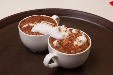 Kedi şeklinde köpüklü kahve ve kahverengi masanın üzerinde fare.