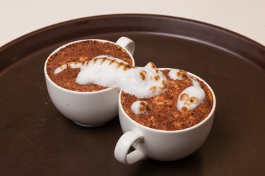 Kedi şeklinde köpüklü kahve ve kahverengi masanın üzerinde fare.