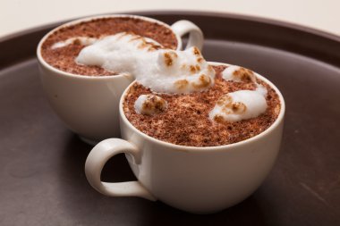 Kedi şeklinde köpüklü kahve ve kahverengi masanın üzerinde fare.