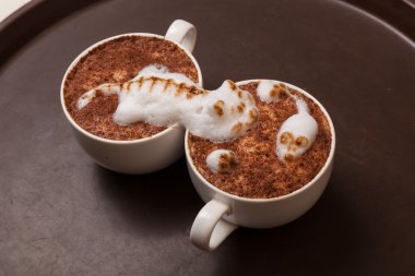 Kedi şeklinde köpüklü kahve ve kahverengi masanın üzerinde fare.