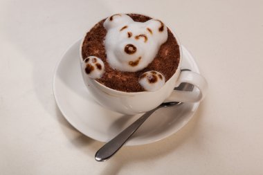 Kedi şeklinde köpüklü kahve ve kahverengi masanın üzerinde fare.