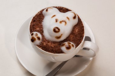 Kedi şeklinde köpüklü kahve ve kahverengi masanın üzerinde fare.