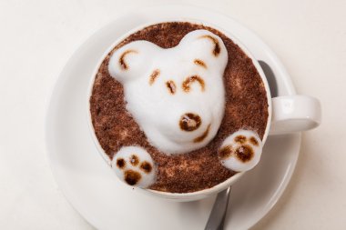 Kedi şeklinde köpüklü kahve ve kahverengi masanın üzerinde fare.