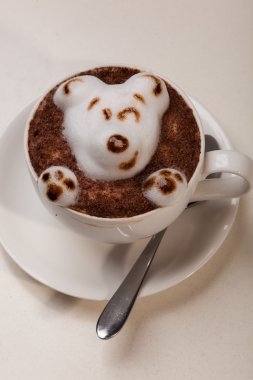 Kedi şeklinde köpüklü kahve ve kahverengi masanın üzerinde fare.