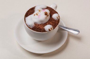 Kedi şeklinde köpüklü kahve ve kahverengi masanın üzerinde fare.