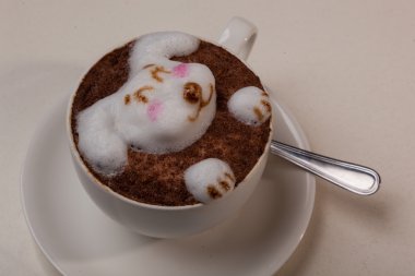 Kedi şeklinde köpüklü kahve ve kahverengi masanın üzerinde fare.