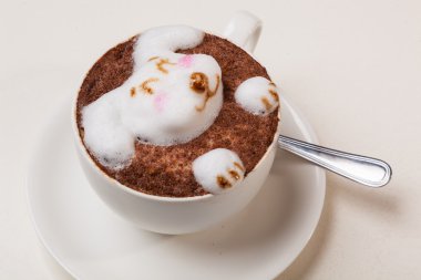 Kedi şeklinde köpüklü kahve ve kahverengi masanın üzerinde fare.