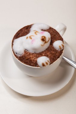 Kedi şeklinde köpüklü kahve ve kahverengi masanın üzerinde fare.