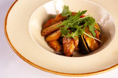 Beyaz arkaplanda kabak ve roka salatası.