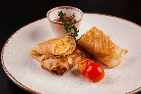 Panqueques con diferente relleno en un plato Imagen De Stock