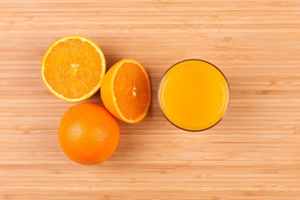 Fresh orange juice glass with sliced fruits - Flat lay — Stock Photo, Image