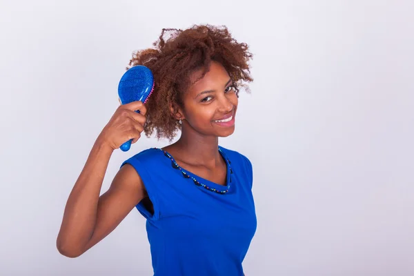 Young African American woman combing her frizzy afro hair - Blac — Stock Photo, Image