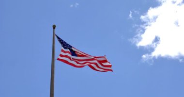 4 k Amerikan bayrağı - yıldız ve bulutlu bir mavi gökyüzü üzerinde yüzen çizgili