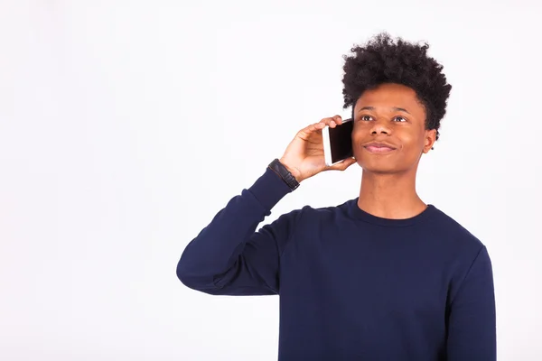 Молодой афроамериканец звонит ей на смартфон — стоковое фото