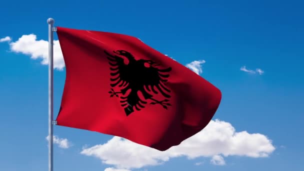 Албанский флаг, размахивающий над голубым облачным небом — стоковое видео